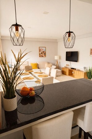 A modern living room with a sofa, a coffee table, and a TV. - Casa Betz Alvor - 2 Bedrooms Apartment | Pool | Near Beach | Indoor Garage (Alvor)