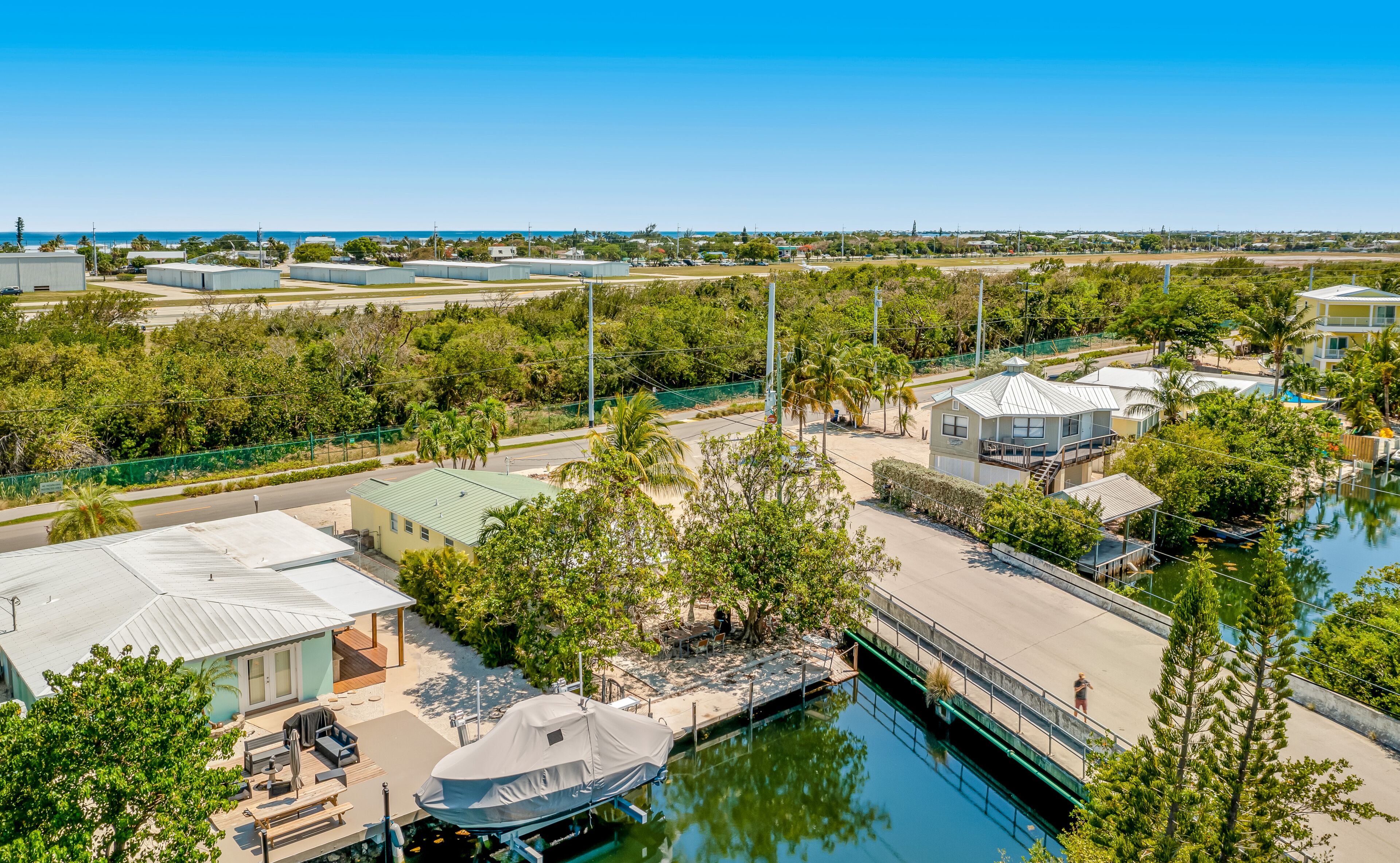 A marina with boats, a dock, and a building with a pool.