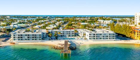 A coastal resort with multiple buildings, a pier, and a beach.
