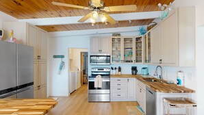 A modern kitchen with wooden flooring, stainless steel appliances, and a wooden countertop. - Saylor's Bay | House in Key Colony Beach with ocean views (Key Colony Beach)