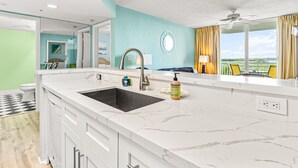 Una cucina moderna con un lavello capiente, mobili bianchi e vista sull'esterno.