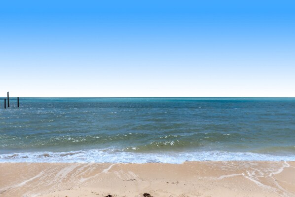 Ein Strand mit klarem, blauen Wasser und einem sandigen Ufer.