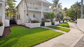 A two-story house with a front porch, white picket fence, and well-maintained lawn. - Duck Key waterfront villa with private pool, kayak, SUP (Duck Key)