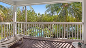 A wooden deck with a white railing, a small table, and a potted plant. - Duck Key waterfront villa with private pool, kayak, SUP (Duck Key)