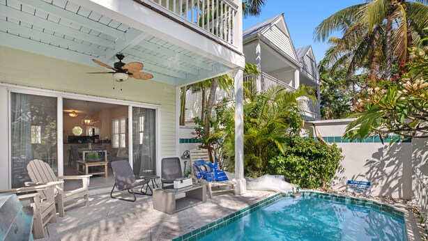 A pool area with lounge chairs, a ceiling fan, and a view of the house. - Duck Key waterfront villa with private pool, kayak, SUP (Duck Key)