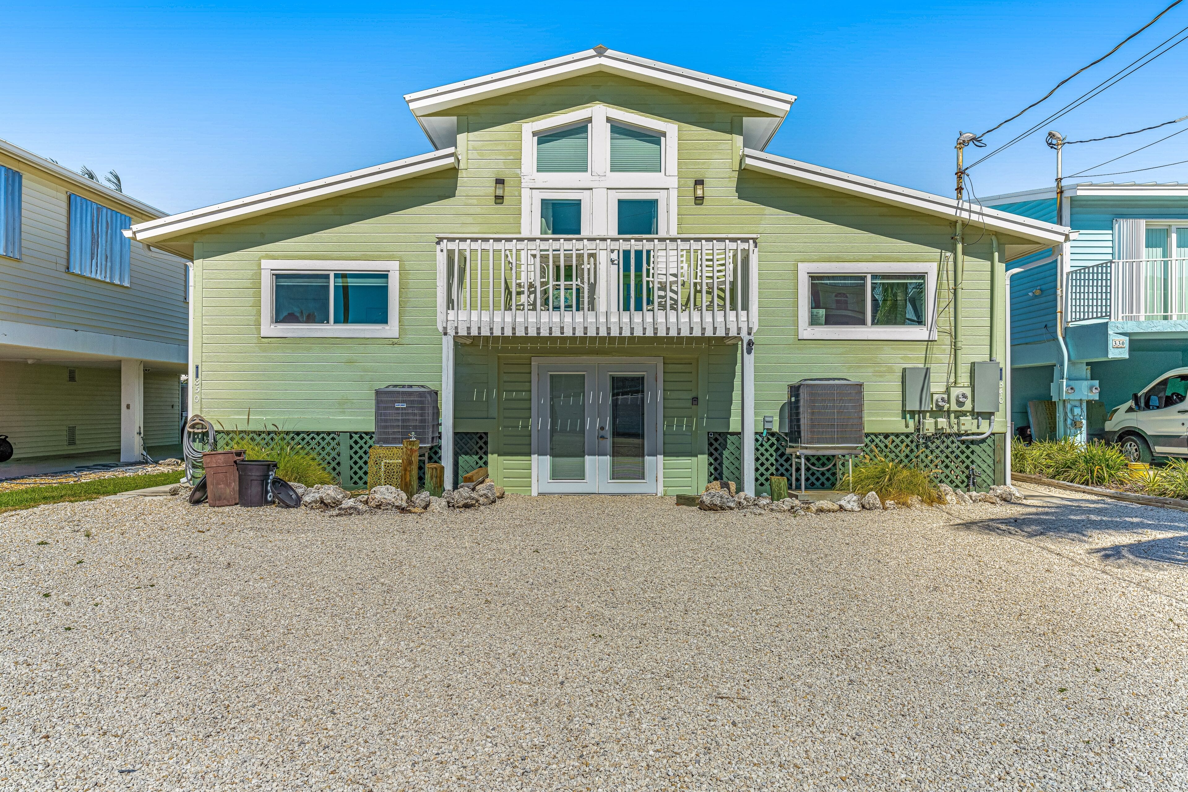 A two-story house with a front porch, a balcony, and a garage.