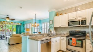A kitchen with white cabinets, a stainless steel dishwasher, a black oven, and a microwave. - Tropical oasis near all the action with central AC & balcony (Duck Key)