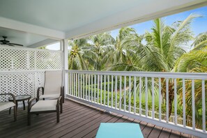 A wooden deck with a white railing, a table, and chairs. - Tropical oasis near all the action with central AC & balcony (Duck Key)