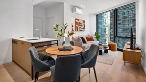 A modern apartment with a kitchen, dining area, and living room. - Chic Apartment Near Crown Casino,pool, Gym & Views (Melbourne)