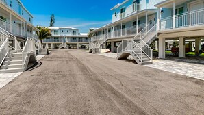 A beachfront hotel with multiple-story buildings, outdoor staircases, and a clear sky. - Gulfside condo with gorgeous views, shared pool, WiFi, & close to attractions (Marathon)