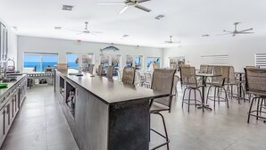 A spacious kitchen with a central island, bar stools, and ceiling fans. - Gulfside condo with gorgeous views, shared pool, WiFi, & close to attractions (Marathon)