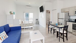 A modern apartment with a living room, dining area, and kitchen. - Gulfside condo with gorgeous views, shared pool, WiFi, & close to attractions (Marathon)