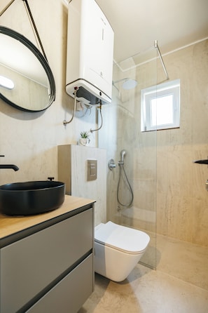 Ein modernes Badezimmer mit Toilette, Waschbecken und Dusche.