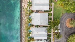A coastal property with three buildings, a dock, and a paved driveway. - Enchanting waterfront townhouse with balcony, mini oasis pool, & washer/dryer (Duck Key)