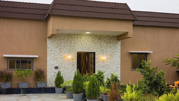 A building with a stone facade, a tiled entrance, and potted plants. - ELIVAAS The Bliss Hushwood 2 BHK Villa  (Mavli)
