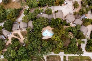 An aerial view of a residential area with multiple houses, a swimming pool, and surrounding greenery. - Branson Family Haven (New Deck) First Responder (Branson)