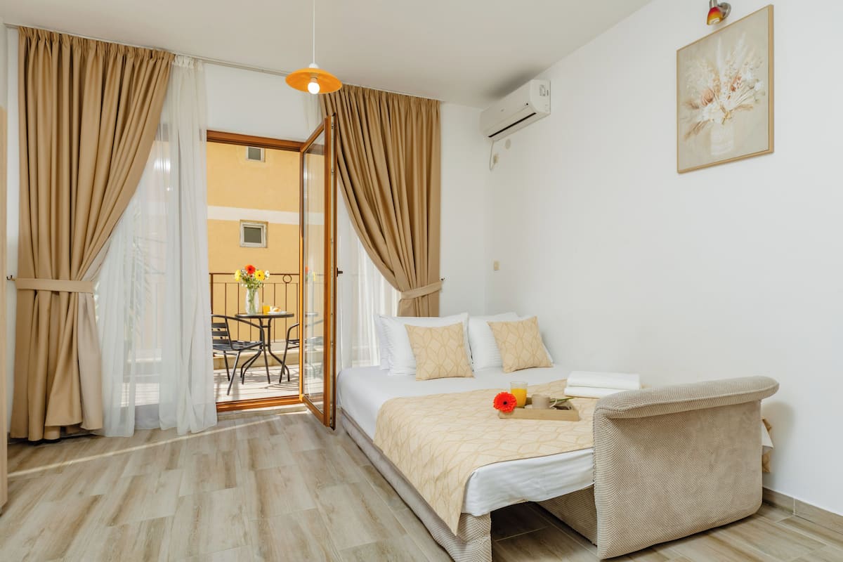 Habitación de hotel con cama, una silla, una mesa y vistas al exterior.