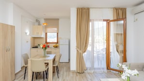 Una cocina moderna con comedor, sofá y vistas a través de un ventanal.