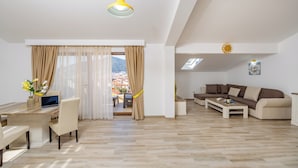 Una sala de estar moderna con comedor, un conjunto de sofás, una mesa de centro y vistas al exterior.
