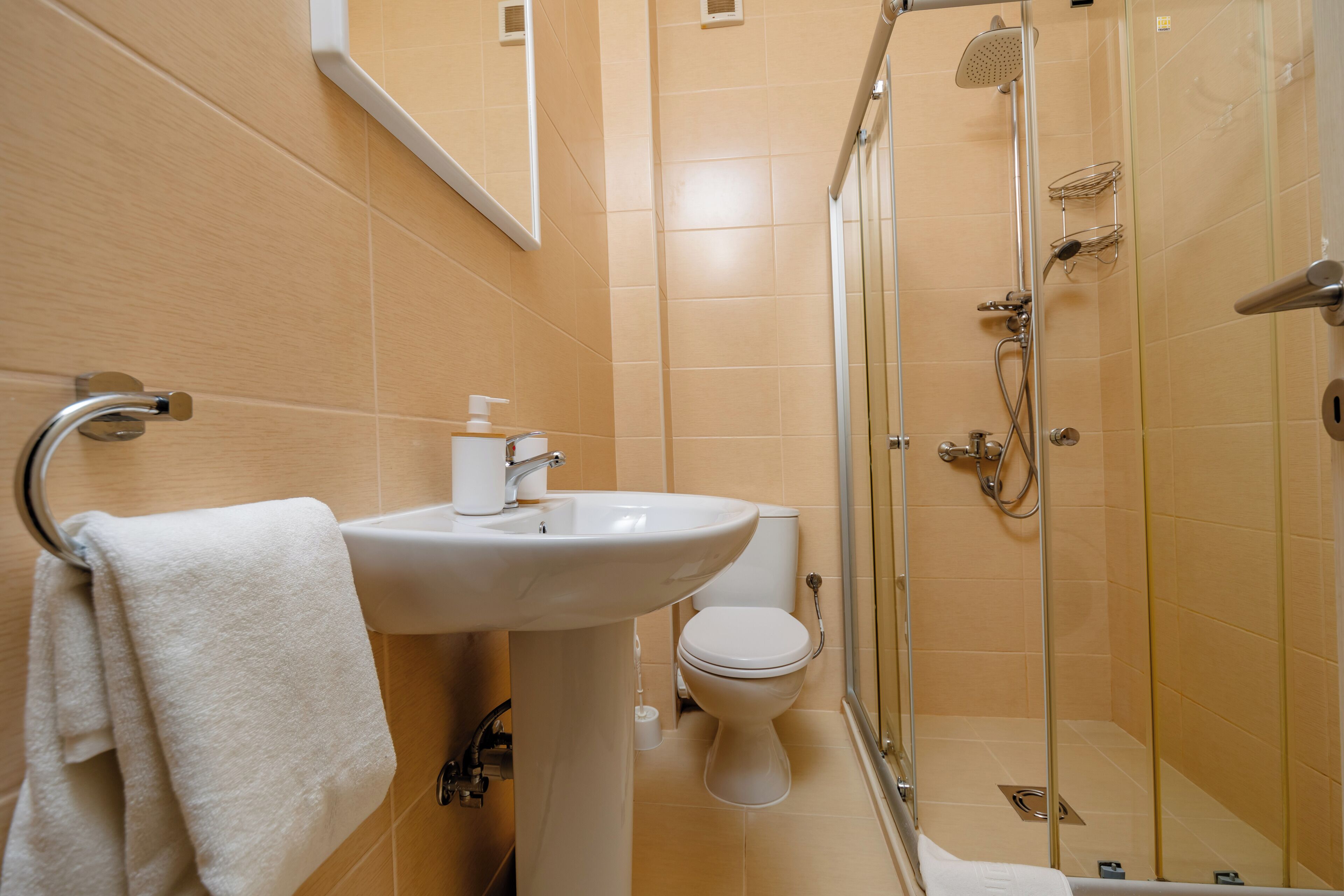 A bathroom with a sink, toilet, and glass-enclosed shower.