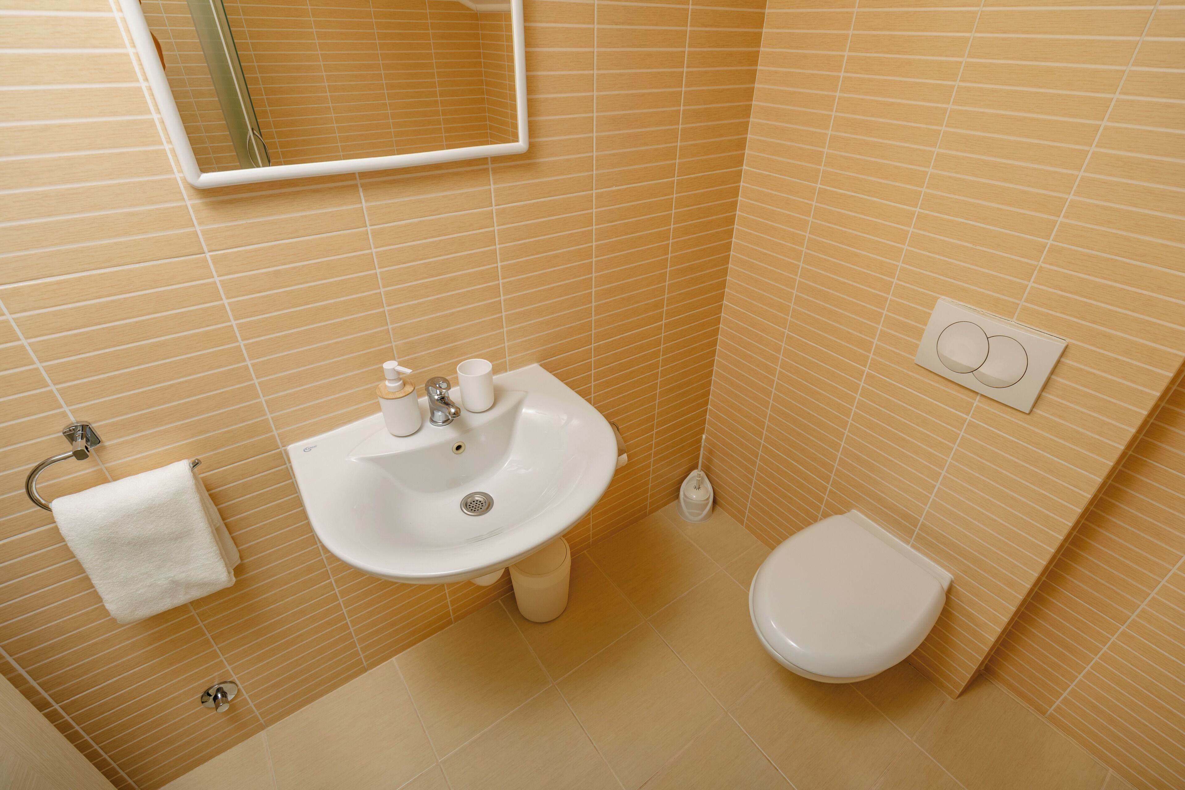 Un bagno con lavandino, WC e specchio.