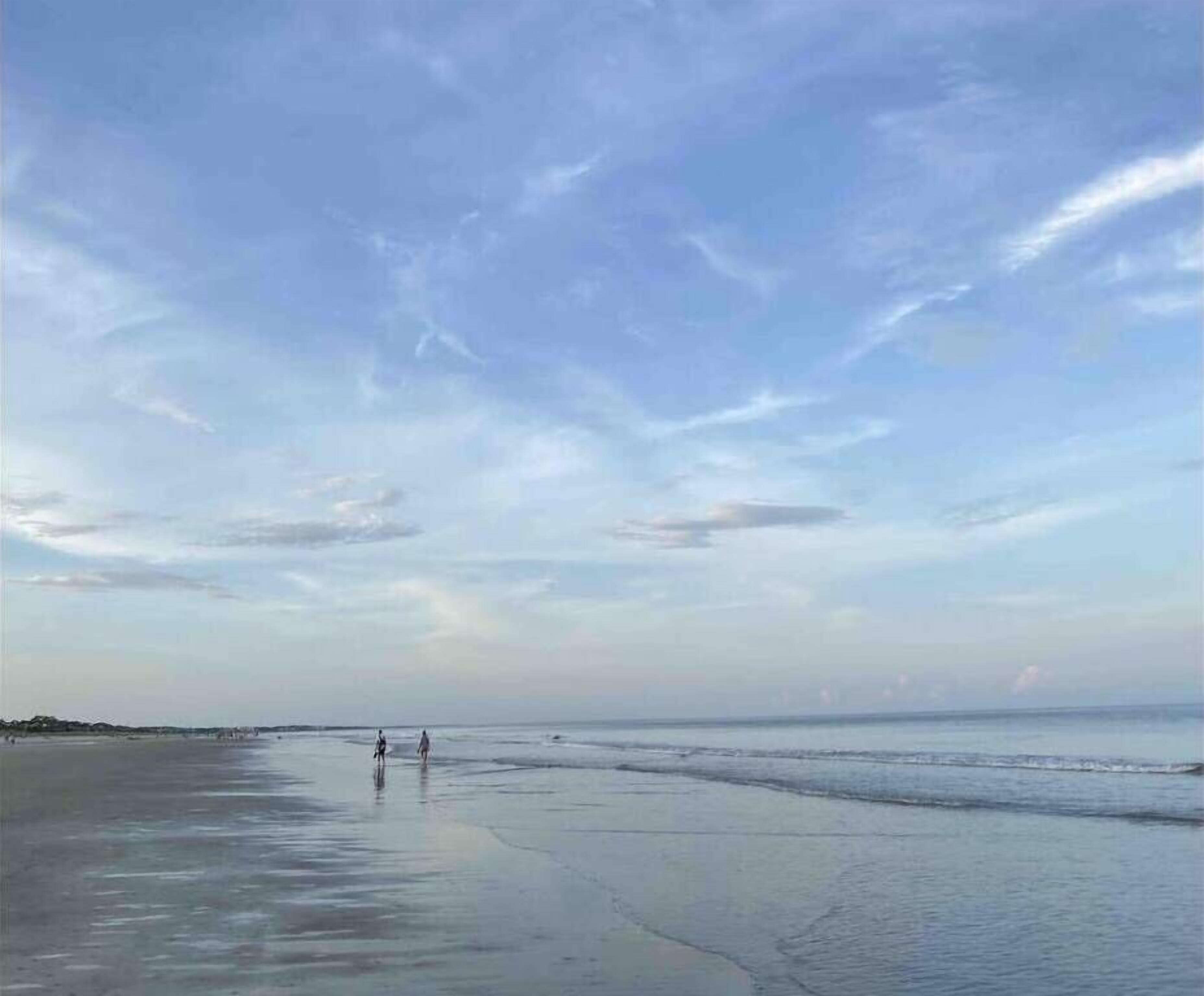 Una playa con cielo despejado y agua tranquila.