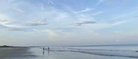 Una playa con cielo despejado y agua tranquila.
