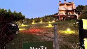 Een bord voor 'Nouli's Mountain View Haven' met een huis op de achtergrond.