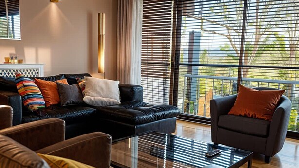 A modern living room with a sectional sofa, a coffee table, and a chair. - Stylish Dulwich Apartment With Parking (London)