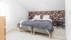 A bedroom with a bed, a nightstand, a chair, and a dresser.