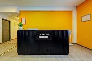 Een receptiebalie met de aanduiding 'TOWNHOUSE' en een bord met de tekst 'Bedrijfskosten'.