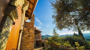 A stone building with a wooden door, a balcony with a metal railing, and a view of the countryside. - Anticuum Gimnasium - Luxury Holiday Villa Sicily with infinity swimming pool (Terme)