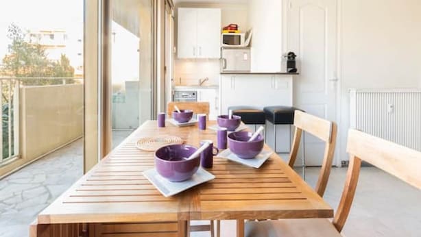 Una cocina moderna con armarios blancos, microondas y cafetera.