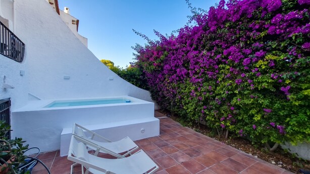 Un edificio blanco con una piscina pequeña y un patio.