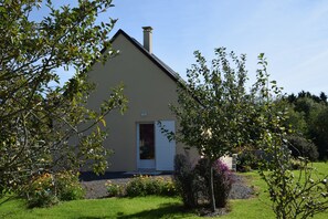 A house with a sloped roof, a chimney, and a door.