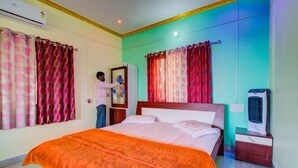 Une chambre d’hôtel équipée d’un lit, de rideaux, d’un climatiseur, d’un radiateur et d’une armoire.