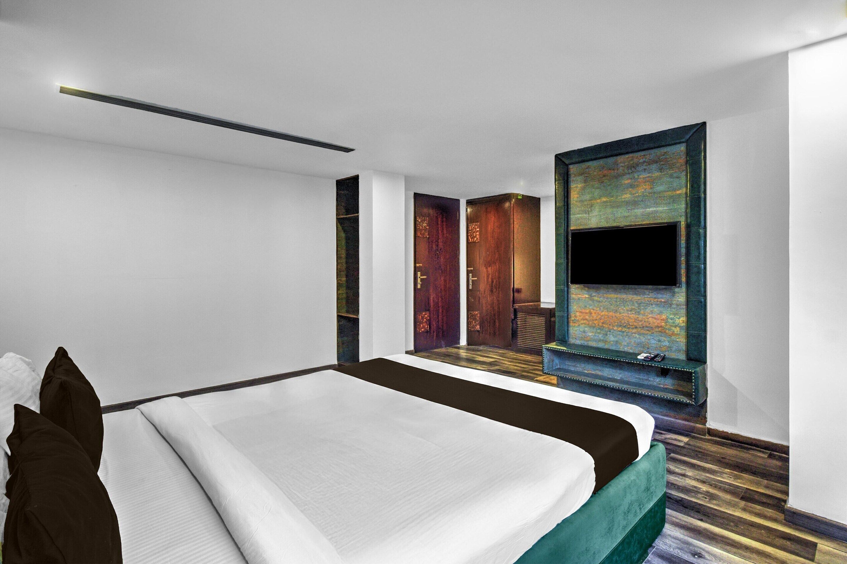 Une chambre d’hôtel moderne équipée d’un lit, d’une télévision et offrant une vue sur un escalier en bois.