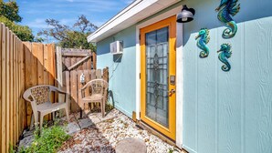 A house with a wooden fence, a glass door with a yellow frame, and decorative seahorse wall art. - Gulfport Studio Near John s Pass the Beach (Gulfport)