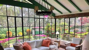 A room with a large window, a sofa, a chair, and a coffee table. - w Charming 4BR Getaway w Pool BBQ Clay Oven (Chaclacayo)