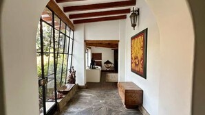 A hallway with stone flooring, wooden beams, and large windows. - w Charming 4BR Getaway w Pool BBQ Clay Oven (Chaclacayo)