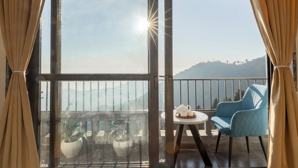 A balcony with a table, chairs, and potted plants. - Alaya Stays Evara Serene 4BHK Villa (Mussoorie)