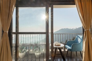 A balcony with a table, chairs, and potted plants. - Alaya Stays Evara Serene 4BHK Villa (Mussoorie)