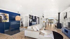 Ein modernes Wohnzimmer mit einer Couch, einem Essbereich und einer Küche.