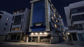 Un edificio moderno con un letrero que dice 'TOWNHOUSE' y el logotipo de un servicio de la empresa.