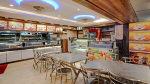 Un restaurante con mostrador, zona de asientos y pizarra de menú.