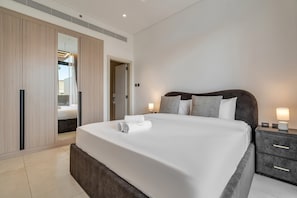 A modern bedroom with a large bed, bedside tables, a wardrobe, and a mirror. - Free Housekeeping Visits During Your Stay - Stayshort - Fresh 2 Bedroom Apartment in JVC That Sleeps 5 (Dubai)