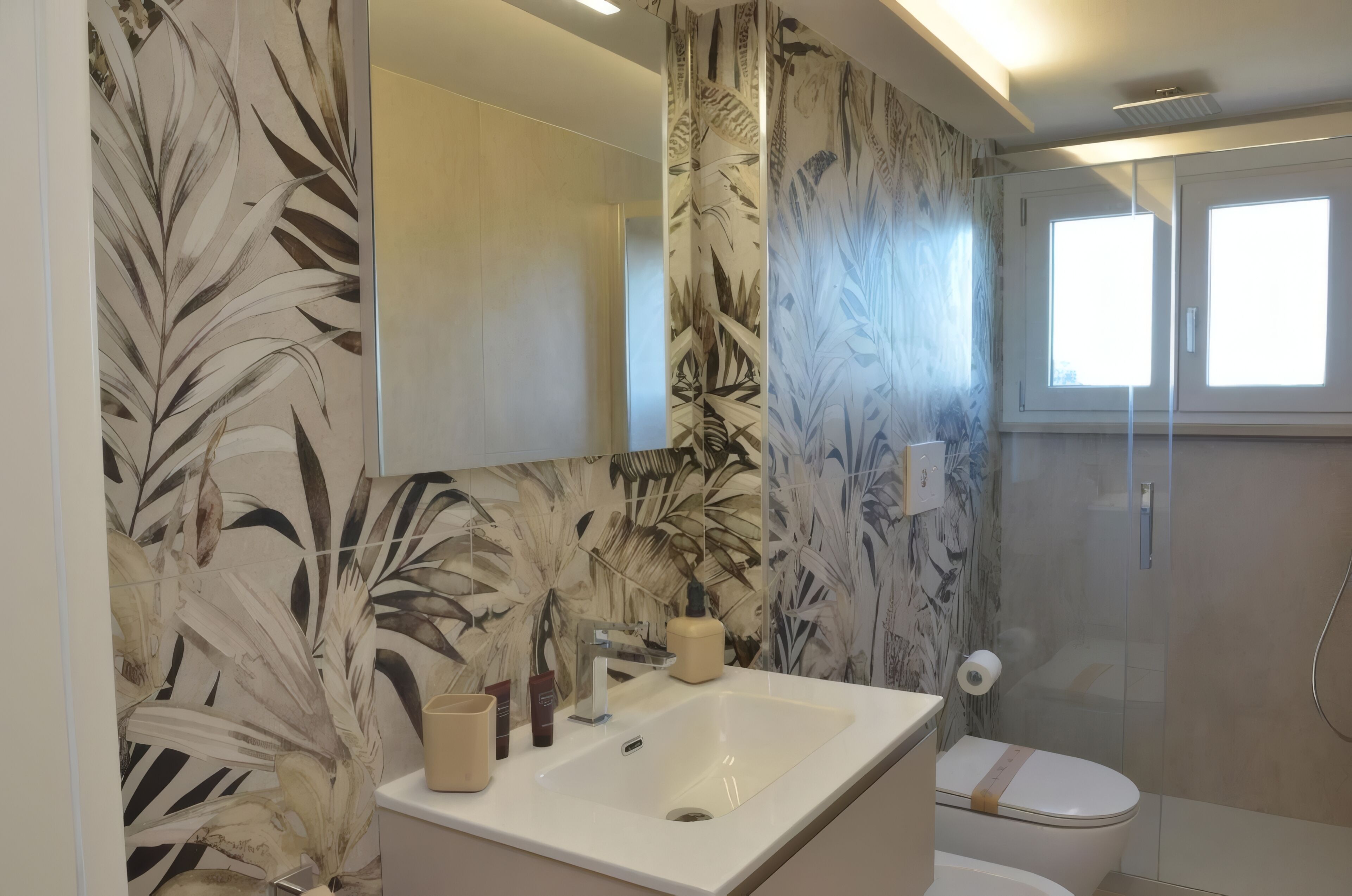 Un baño con lavamanos, inodoro y ducha blancos.