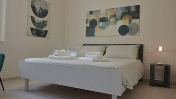Un dormitorio moderno con una cama grande, una mesita de noche y arte abstracto en la pared.