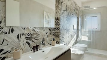 Ein Badezimmer mit einem großen Spiegel, zwei Waschbecken, einer Toilette und einer Dusche.