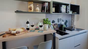 Una cocina moderna con encimera de madera, botellas de vino, una cafetera y un fregadero.